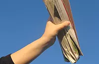 Zeitungsrolle in einer Hand